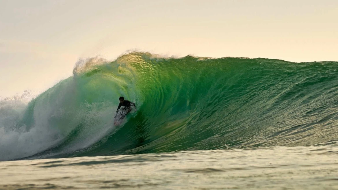 Dwi Putrawan surfing di dalam ombak hijau